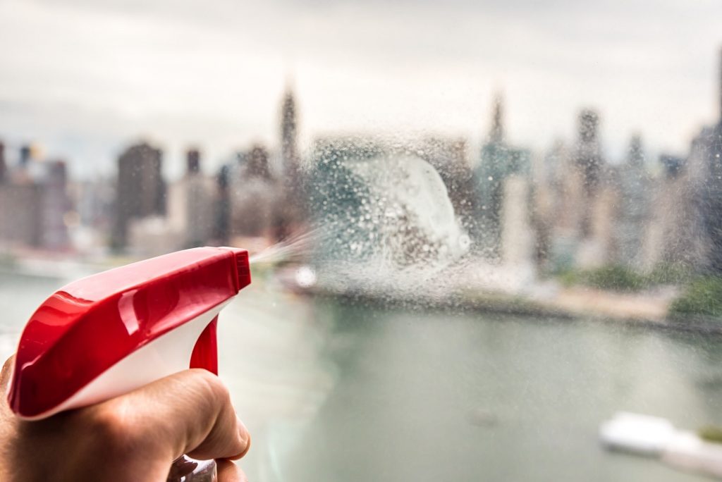 Cleaning the window with Manhattan skyline on the background